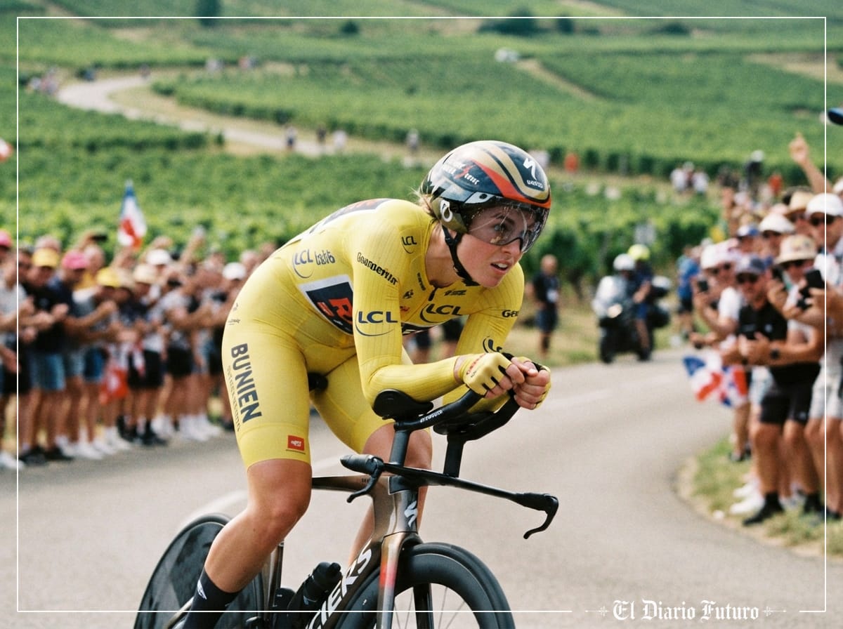 Ciclista con maillot amarillo en posición aerodinámica sobre una bicicleta de contrarreloj entre viñedos.